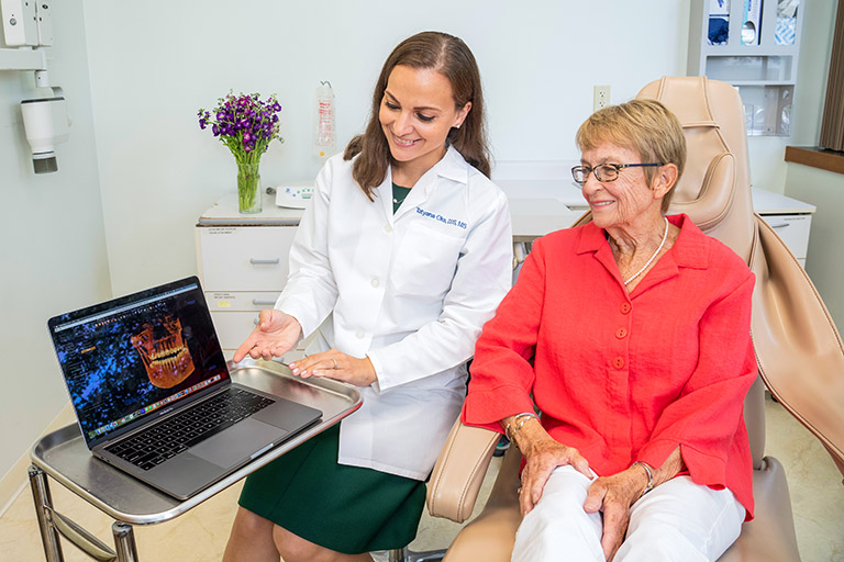 Doctor showing her patient the implant planning software